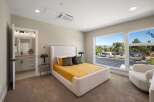 Experience modern comfort in this beautifully appointed bedroom, featuring a plush white bouclé bed and a vibrant yellow quilted comforter.