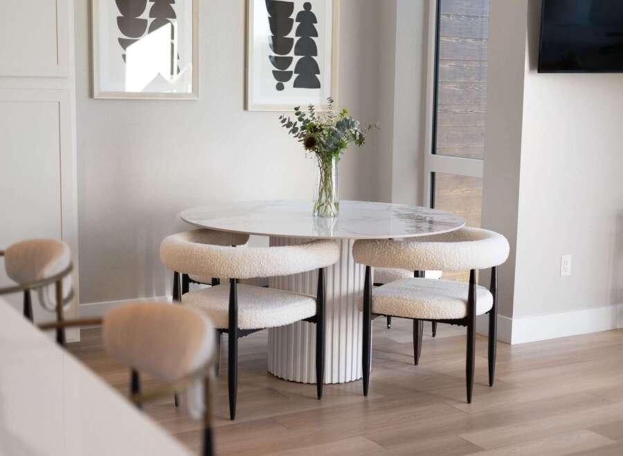 Experience modern dining with this stylish round table featuring a marble-look top and a fluted pedestal base.