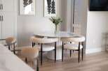 Experience modern dining with this stylish round table featuring a marble-look top and a fluted pedestal base.