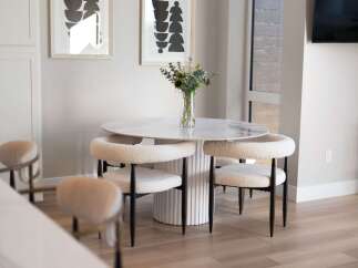 Experience modern dining with this stylish round table featuring a marble-look top and a fluted pedestal base.