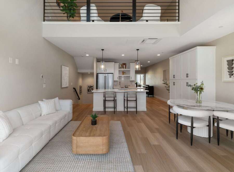 Experience modern living in this stunning open-concept home featuring a spacious living area with a plush sectional sofa and a sleek coffee table.