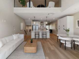 Experience modern living in this stunning open-concept home featuring a spacious living area with a plush sectional sofa and a sleek coffee table.