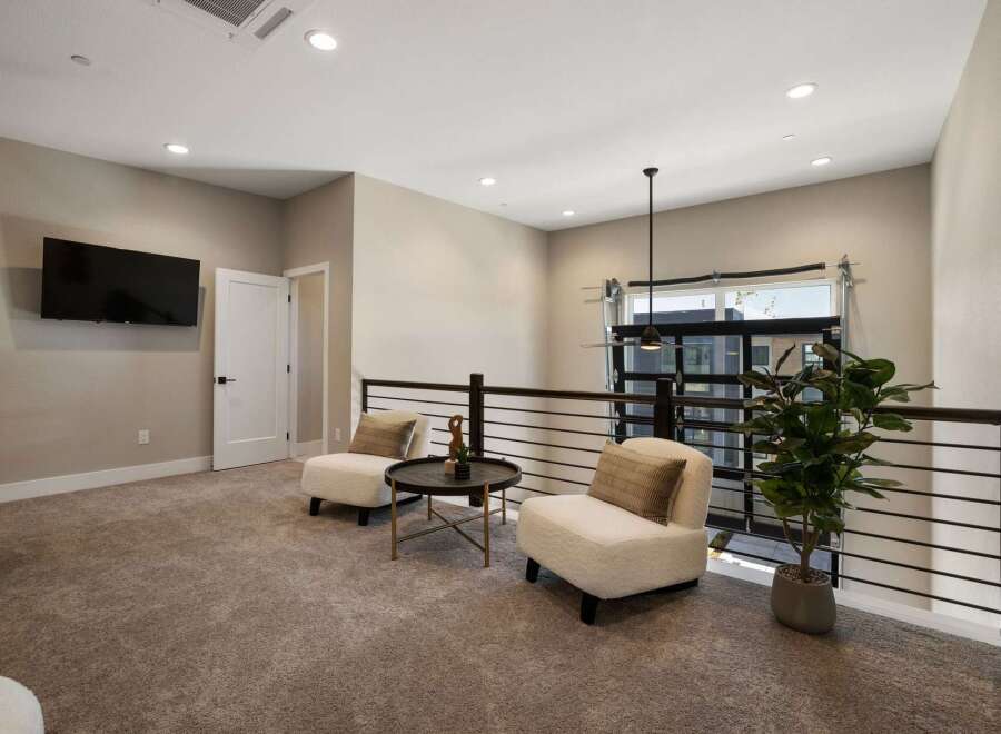 This loft space offers a cozy seating area with two plush armchairs and a modern coffee table, perfect for relaxation or conversation.