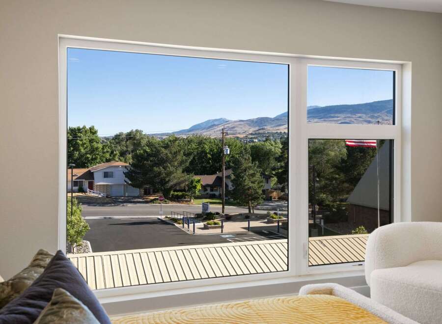 Experience breathtaking mountain views from this stunning property, framed by a large, modern window.