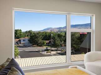 Experience breathtaking mountain views from this stunning property, framed by a large, modern window.