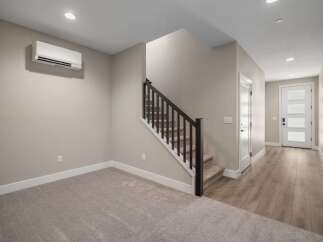 Discover modern living in this spacious home featuring a sleek, wall-mounted air conditioning unit for optimal comfort.