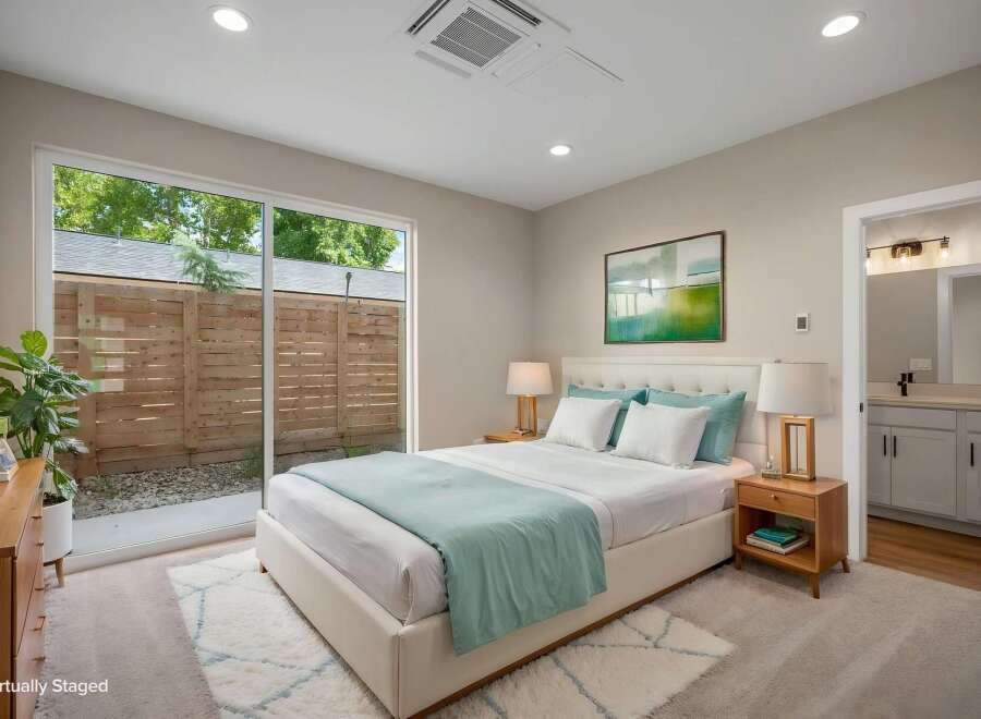 Experience modern living in this beautifully staged bedroom, featuring a plush king-sized bed with crisp white linens and accent pillows.