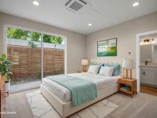 Experience modern living in this beautifully staged bedroom, featuring a plush king-sized bed with crisp white linens and accent pillows.