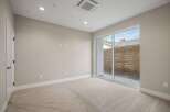 Step into this inviting room featuring plush carpeting and a modern sliding glass door that opens to a private outdoor space.