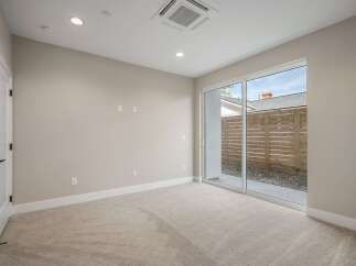 Step into this inviting room featuring plush carpeting and a modern sliding glass door that opens to a private outdoor space.