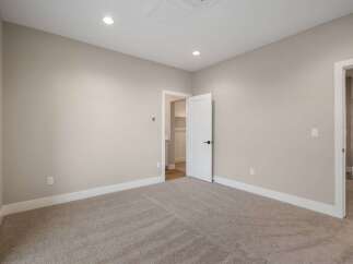 Step into this inviting bedroom, featuring plush carpeting and neutral-toned walls that create a serene atmosphere.