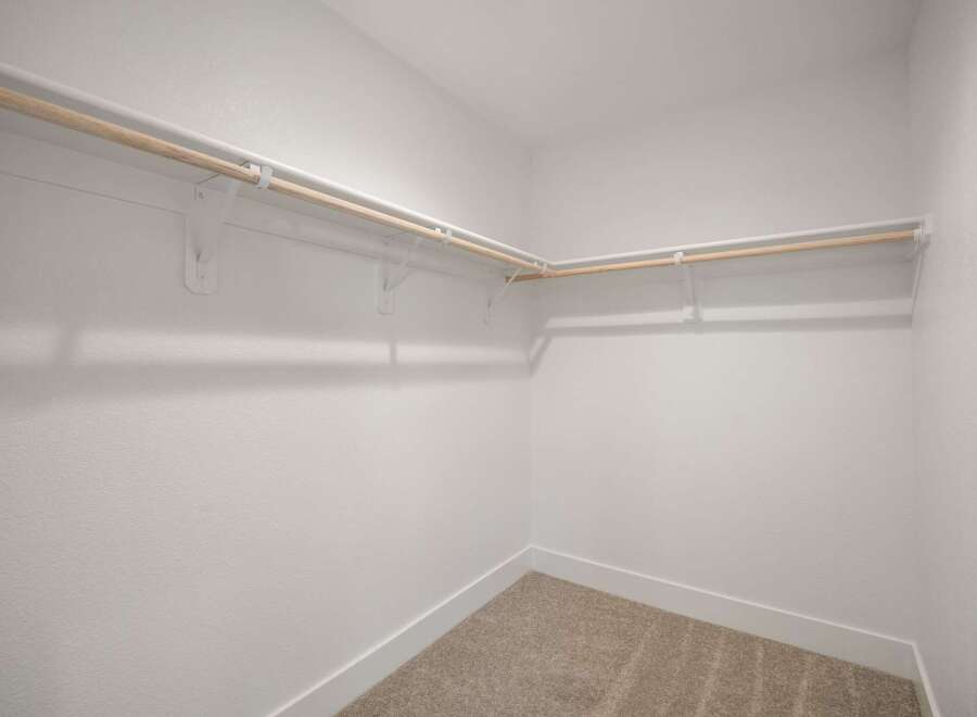 Discover ample storage in this spacious walk-in closet, featuring a double-rod system for organized hanging space.