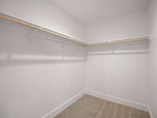 Discover ample storage in this spacious walk-in closet, featuring a double-rod system for organized hanging space.
