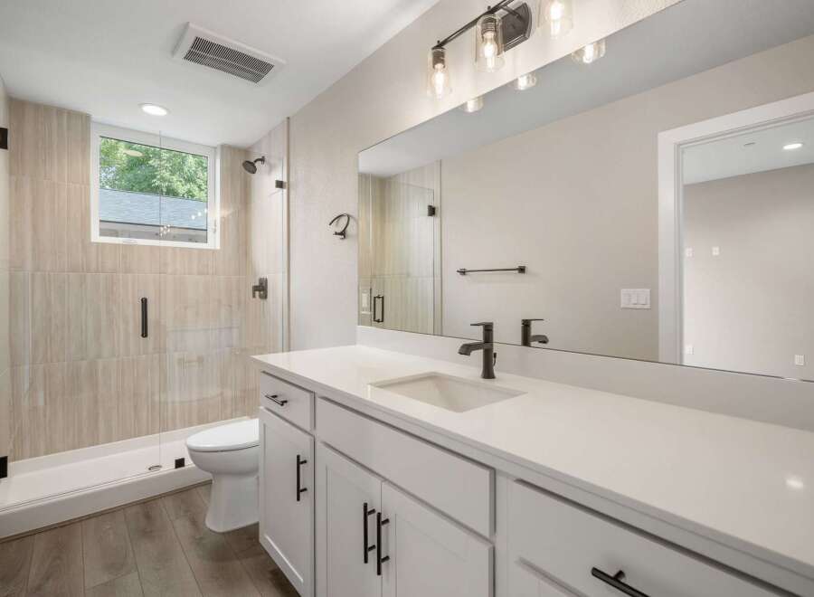 This modern bathroom features a spacious walk-in shower with elegant tilework and a sleek glass enclosure.