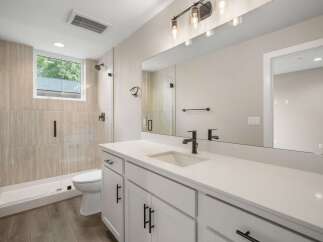This modern bathroom features a spacious walk-in shower with elegant tilework and a sleek glass enclosure.
