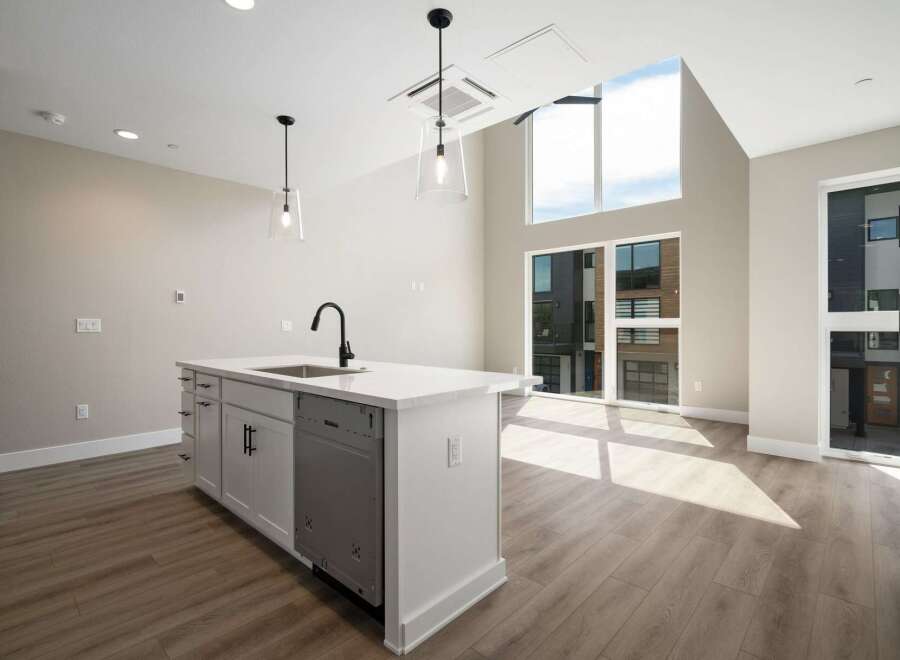 Experience modern living in this stunning kitchen featuring a sleek island with a built-in sink and contemporary faucet.