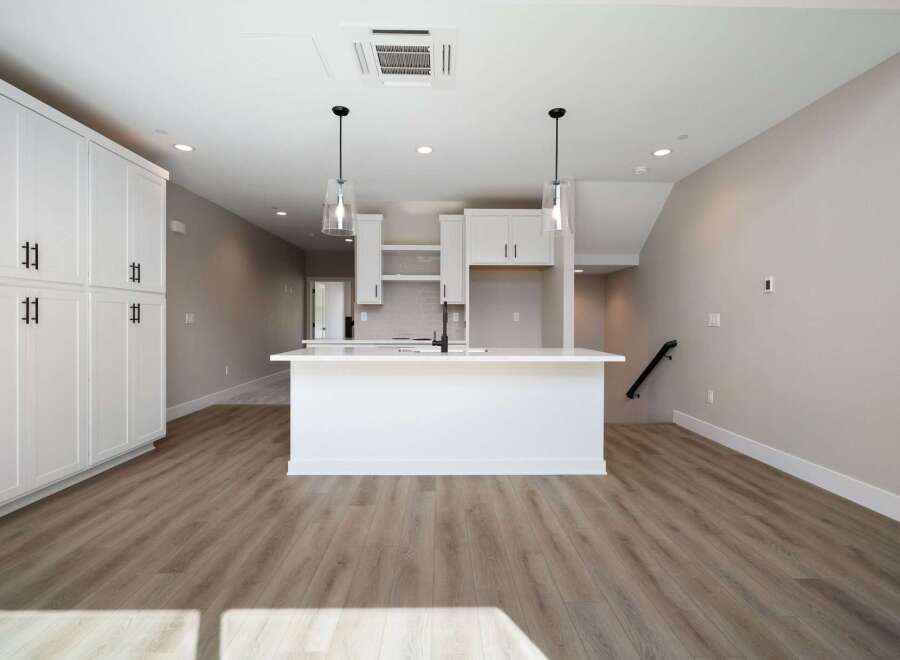 Experience modern living in this stunning kitchen featuring sleek white cabinetry and a spacious island perfect for entertaining.