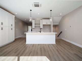 Experience modern living in this stunning kitchen featuring sleek white cabinetry and a spacious island perfect for entertaining.