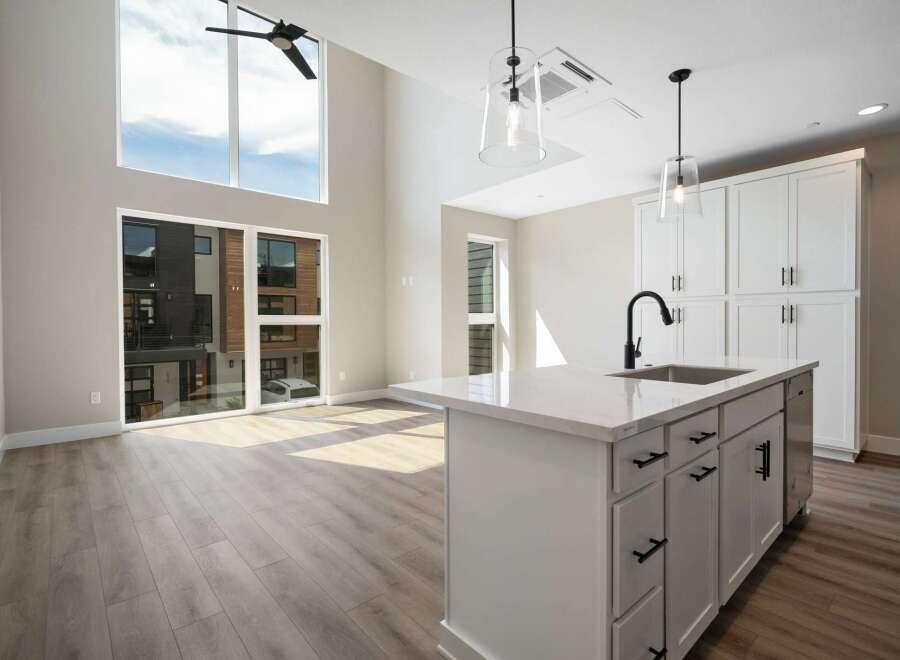 Experience modern living in this stunning open-concept space featuring soaring ceilings and abundant natural light pouring through large windows.