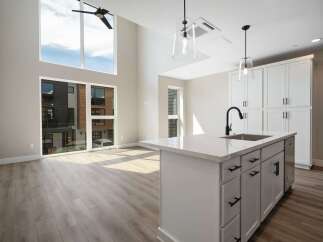 Experience modern living in this stunning open-concept space featuring soaring ceilings and abundant natural light pouring through large windows.