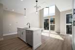 Experience modern living in this stunning kitchen featuring a sleek island with a built-in sink and contemporary faucet.