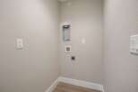 This laundry room is equipped with essential hookups for your washer and dryer, including a dedicated dryer vent and water connections.
