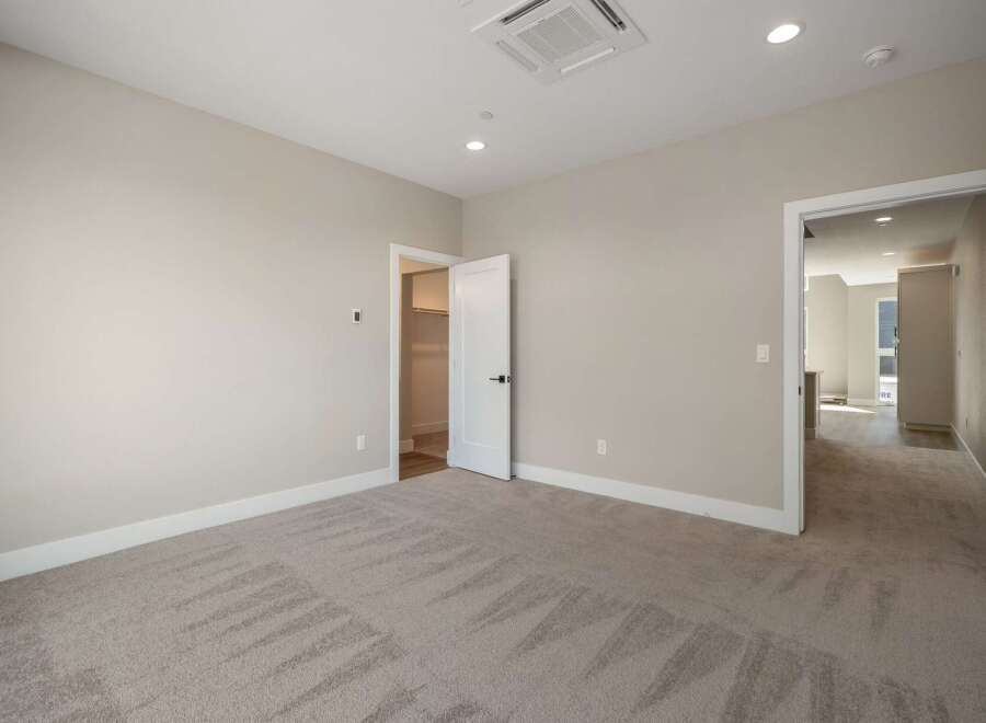 Step into this beautifully appointed bedroom, featuring plush carpeting and neutral-toned walls that create a serene atmosphere.