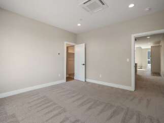 Step into this beautifully appointed bedroom, featuring plush carpeting and neutral-toned walls that create a serene atmosphere.