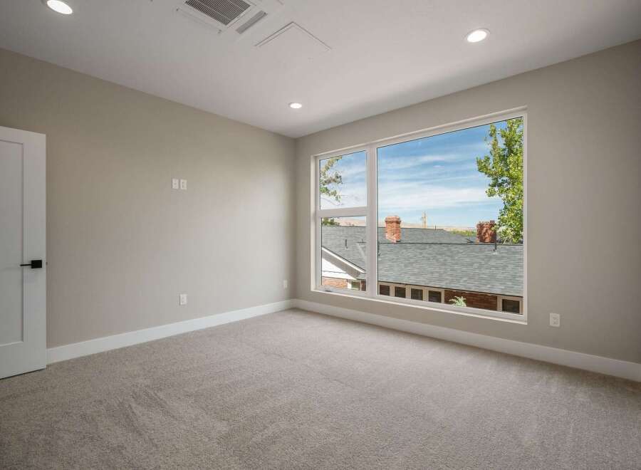 Step into this bright and airy bedroom, featuring a large window that floods the space with natural light and offers picturesque views of the neighborhood.