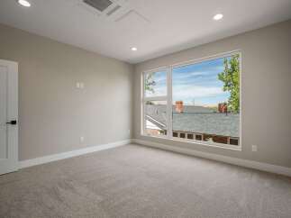 Step into this bright and airy bedroom, featuring a large window that floods the space with natural light and offers picturesque views of the neighborhood.