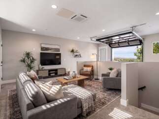 Experience modern living in this stylish living room featuring a comfortable sectional sofa, a sleek entertainment center, and a warm wooden coffee table.