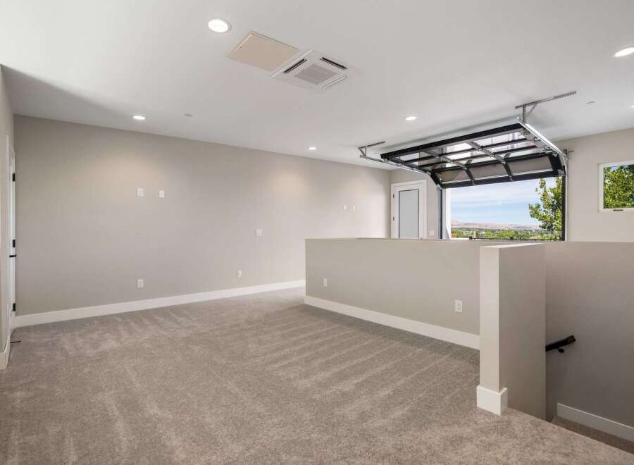 Discover this spacious loft area featuring plush carpeting and neutral-toned walls, perfect for a home office or entertainment space.