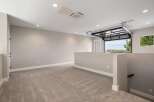 Discover this spacious loft area featuring plush carpeting and neutral-toned walls, perfect for a home office or entertainment space.