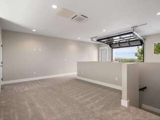 Discover this spacious loft area featuring plush carpeting and neutral-toned walls, perfect for a home office or entertainment space.