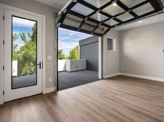 Experience modern living with this stunning property featuring a unique glass garage door that opens to a spacious outdoor deck, perfect for entertaining or enjoying the fresh air.