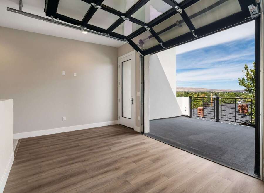 Experience breathtaking views from this unique property, featuring a modern glass garage door that opens to a spacious balcony.