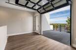 Experience breathtaking views from this unique property, featuring a modern glass garage door that opens to a spacious balcony.