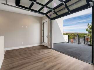 Experience breathtaking views from this unique property, featuring a modern glass garage door that opens to a spacious balcony.