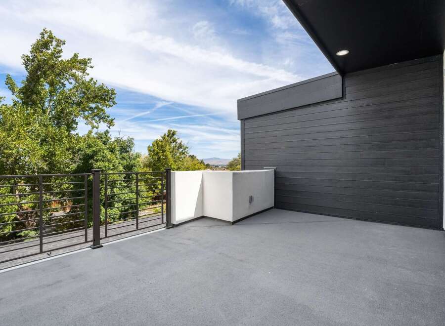 Experience modern living with this stunning balcony, featuring sleek dark wood siding and a minimalist white planter.