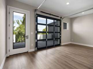 Experience modern living with this stunning garage featuring a sleek glass garage door that floods the space with natural light.