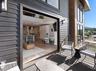 Experience seamless indoor-outdoor living with this modern home featuring a spacious balcony overlooking a scenic landscape.