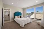 Experience modern comfort in this spacious bedroom featuring a luxurious tufted headboard and plush carpeting.