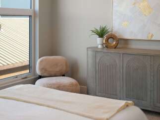 Discover modern comfort in this beautifully appointed bedroom, featuring a plush, textured accent chair perfect for relaxation.
