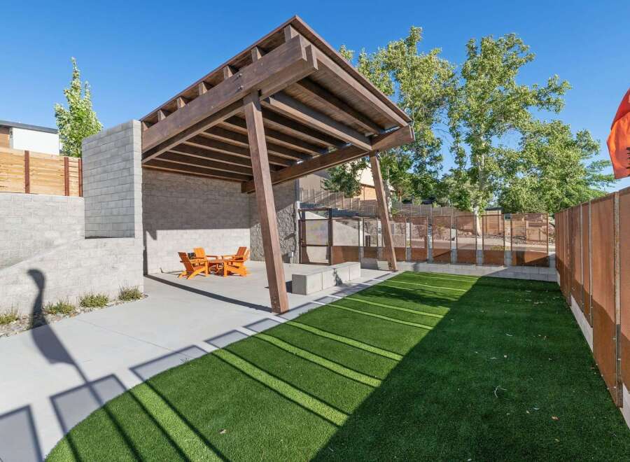 Discover this modern outdoor living space featuring a covered wooden pergola and a built-in seating area, perfect for entertaining.