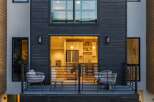 Experience modern living in this stunning townhouse featuring a sleek dark wood exterior and expansive windows.