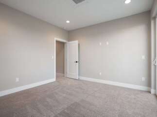 Step into this beautifully appointed room featuring plush carpeting and neutral-toned walls, creating a serene and inviting atmosphere.