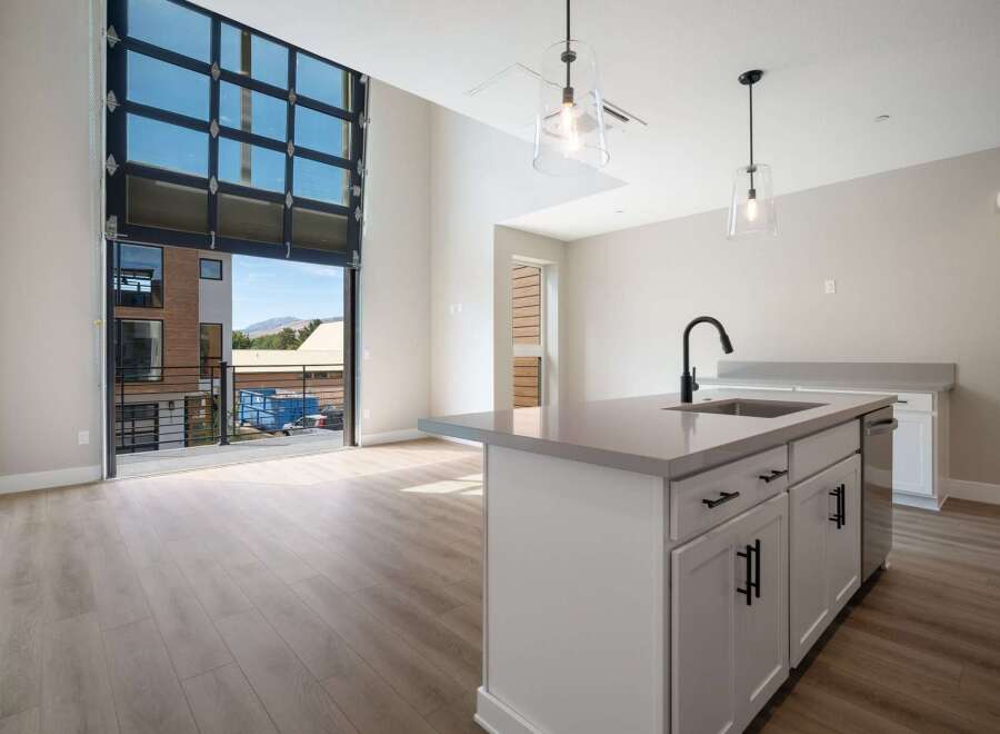 Experience modern living in this stunning apartment featuring a unique, oversized glass garage door that opens to a private balcony, blurring the lines between indoor and outdoor spaces.