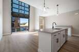 Experience modern living in this stunning apartment featuring a unique, oversized glass garage door that opens to a private balcony, blurring the lines between indoor and outdoor spaces.