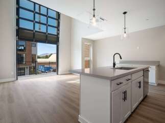 Experience modern living in this stunning apartment featuring a unique, oversized glass garage door that opens to a private balcony, blurring the lines between indoor and outdoor spaces.