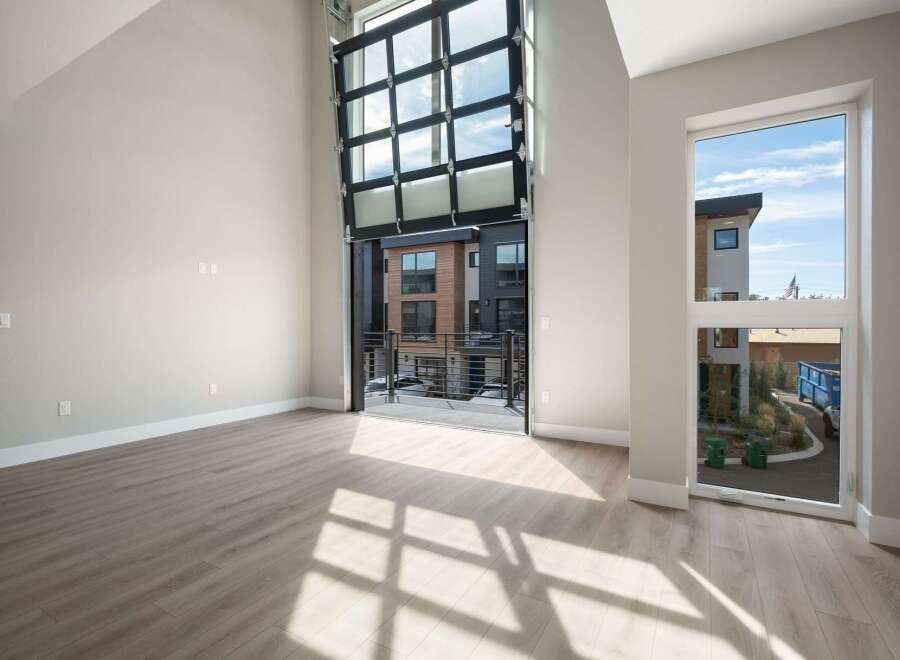 Experience modern living in this spacious, light-filled home featuring a dramatic floor-to-ceiling glass garage door that opens to a private balcony.